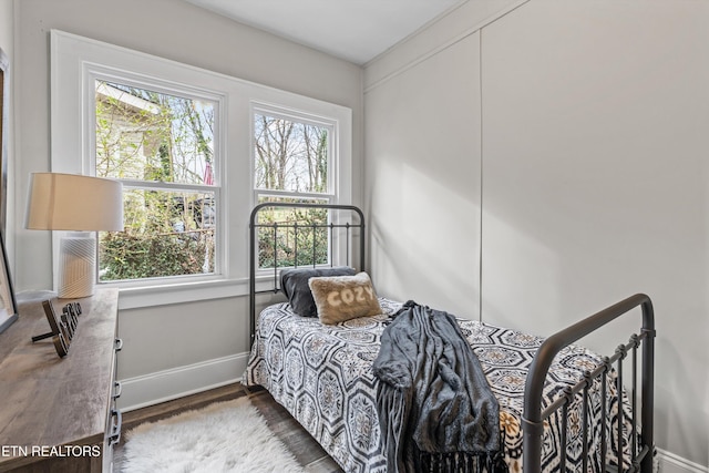 bedroom featuring wood finished floors and baseboards