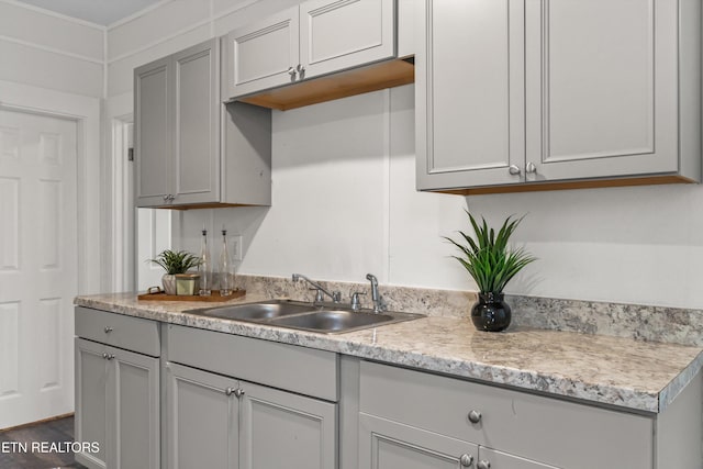 kitchen featuring gray cabinets, light countertops, and a sink