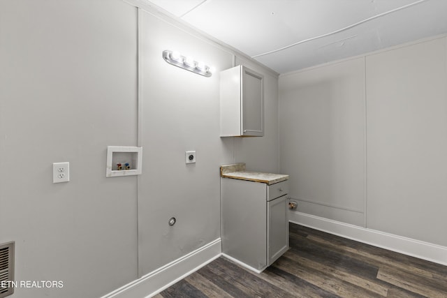 clothes washing area with baseboards, hookup for a washing machine, dark wood-style floors, cabinet space, and hookup for an electric dryer