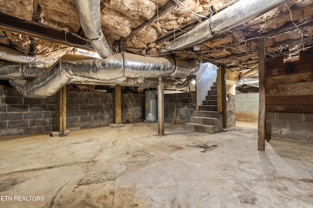 unfinished below grade area featuring water heater and stairway