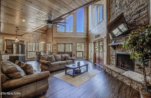 living room with wooden ceiling, wooden walls, dark wood-type flooring, and ceiling fan