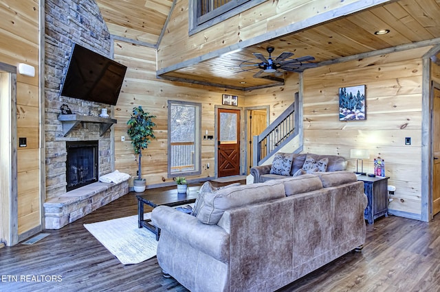 living room with stairway, wood finished floors, a ceiling fan, a fireplace, and wooden ceiling