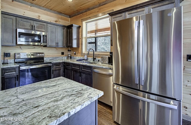 kitchen featuring a sink, light stone counters, wood ceiling, and stainless steel appliances