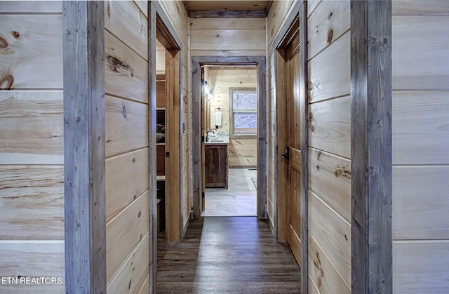 hall with wood walls and wood finished floors