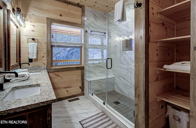 bathroom with visible vents, marble finish floor, a sink, wooden walls, and a shower stall