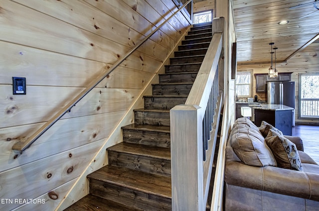 stairs featuring wooden ceiling, wood finished floors, and wood walls