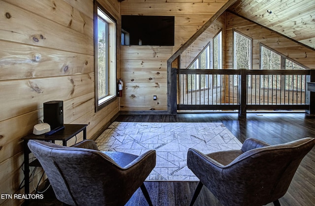 sitting room with lofted ceiling, wooden walls, wood ceiling, and wood finished floors