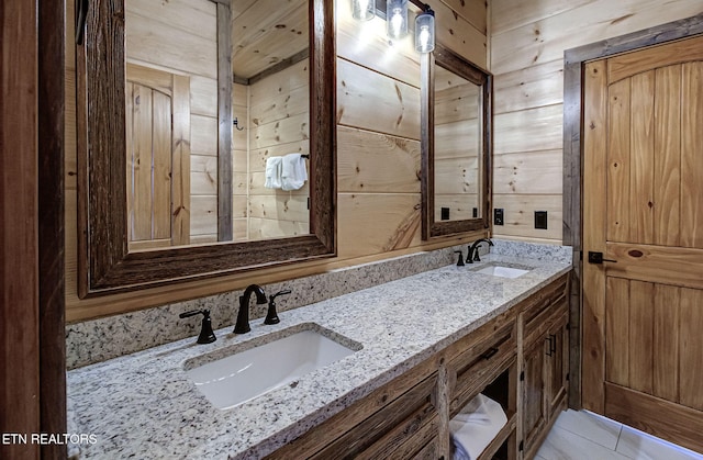 full bathroom featuring a sink, wooden walls, and double vanity