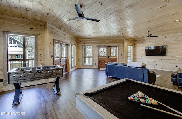 recreation room with wood finished floors, wooden ceiling, a ceiling fan, and wood walls