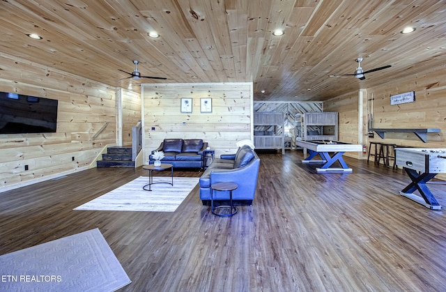 living room featuring dark wood-type flooring, ceiling fan, wooden ceiling, and wood walls