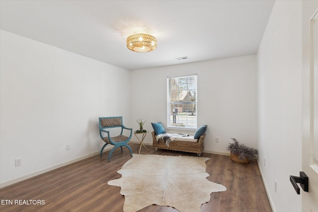 sitting room featuring visible vents, baseboards, and wood finished floors