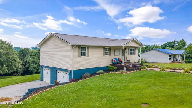 view of front facade with driveway, a porch, a front lawn, a garage, and metal roof