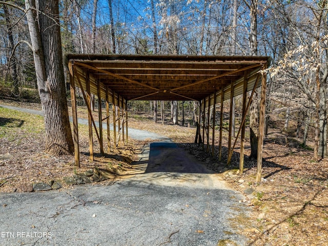 view of parking / parking lot featuring aphalt driveway and a carport