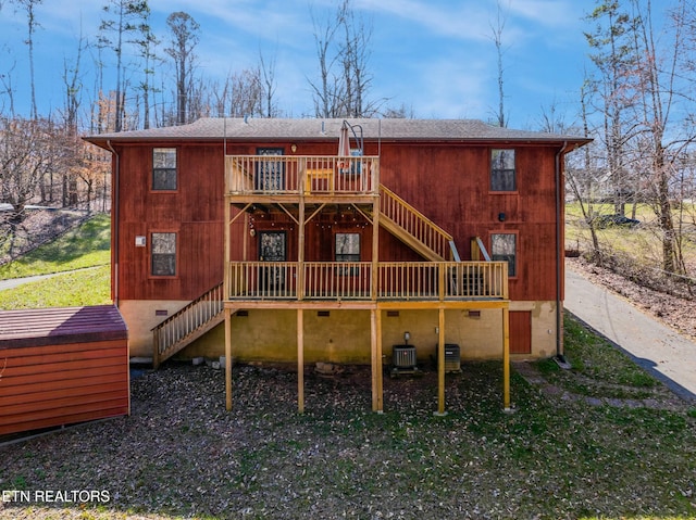 back of house with crawl space, stairway, a jacuzzi, and a deck