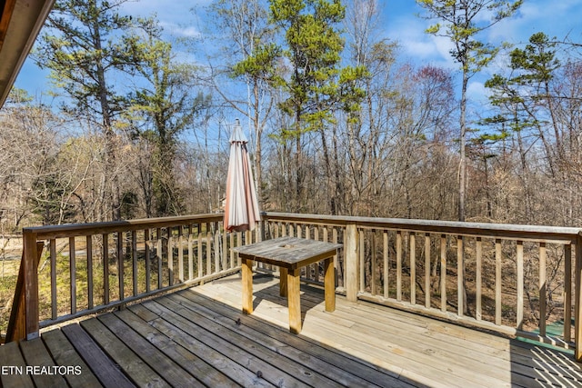 wooden deck featuring a forest view