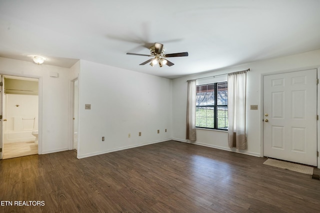 unfurnished living room with dark wood finished floors, a ceiling fan, and baseboards