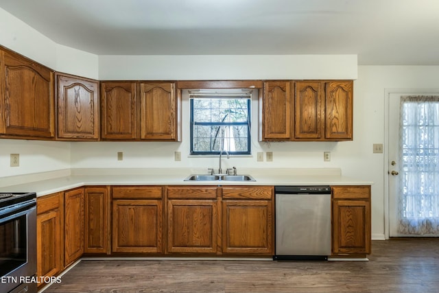 kitchen with dark wood finished floors, brown cabinetry, appliances with stainless steel finishes, and a sink