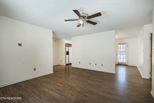 unfurnished living room with baseboards, dark wood finished floors, and a ceiling fan