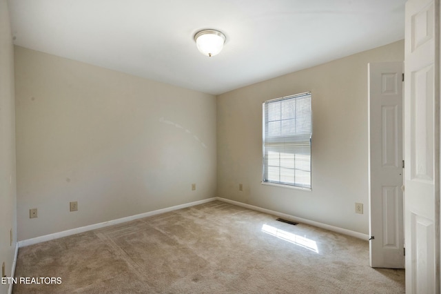 unfurnished room with visible vents, baseboards, and carpet floors