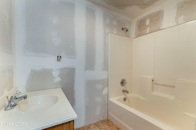 full bath featuring washtub / shower combination, vanity, and wood finished floors