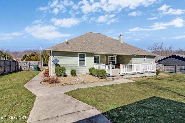 rear view of property featuring a yard, a fenced backyard, a chimney, and a shingled roof