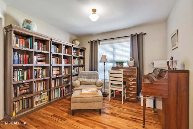 living area featuring bookshelves and wood finished floors