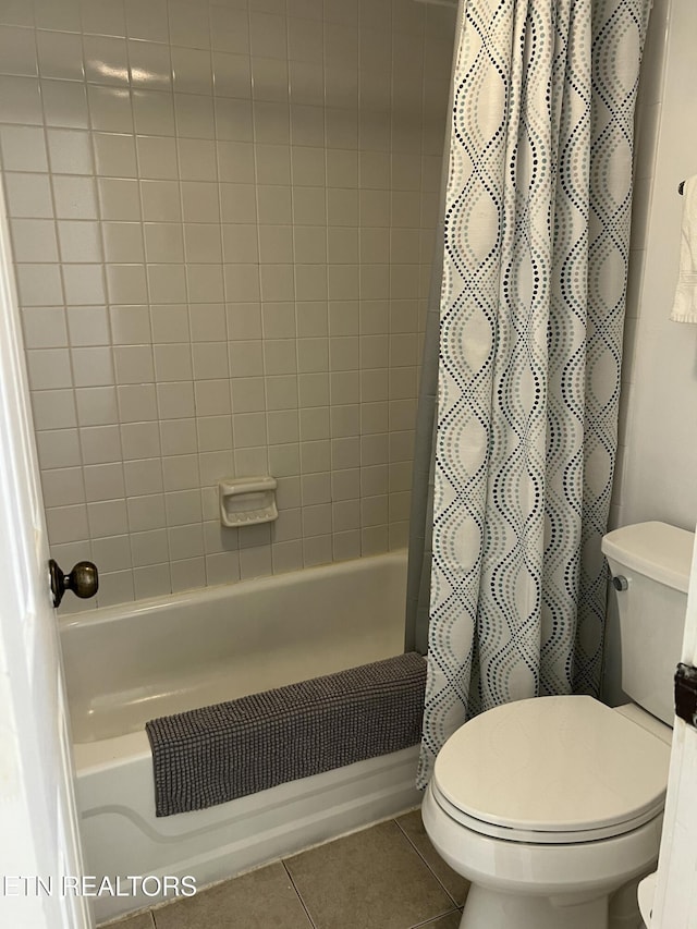 bathroom featuring tile patterned floors, toilet, and shower / bathtub combination with curtain