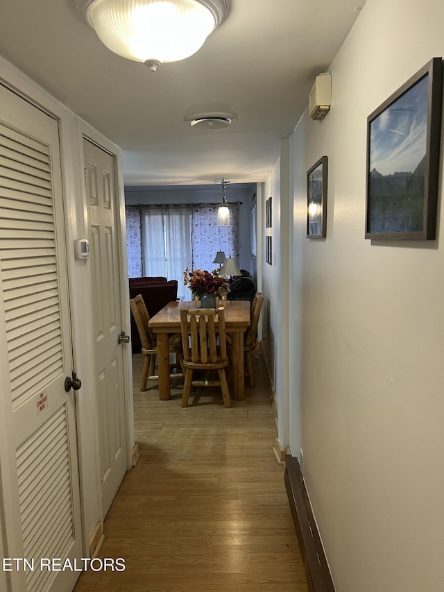 hallway featuring baseboards and wood finished floors