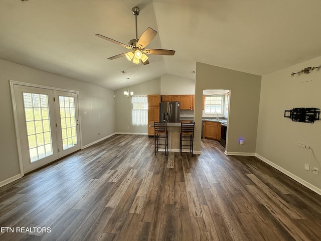 kitchen featuring brown cabinets, ceiling fan with notable chandelier, a sink, dark wood-style floors, and stainless steel fridge