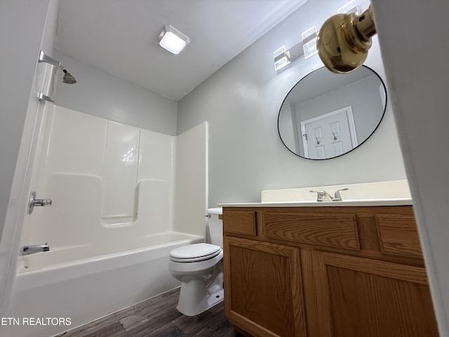 bathroom featuring bathing tub / shower combination, toilet, wood finished floors, and vanity