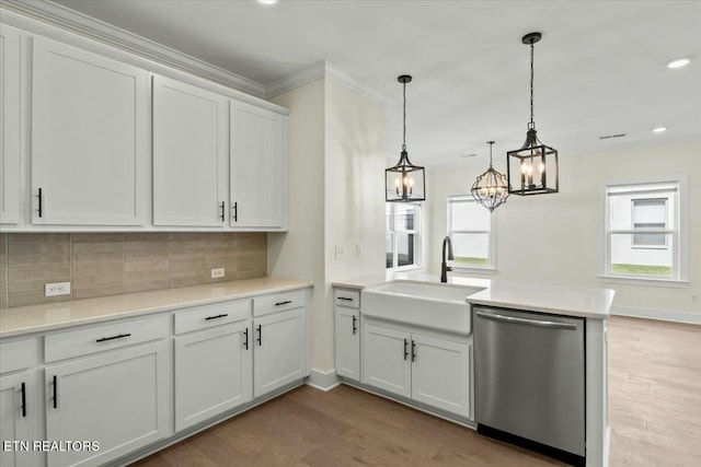 kitchen featuring light wood-style flooring, a sink, stainless steel dishwasher, a peninsula, and decorative backsplash