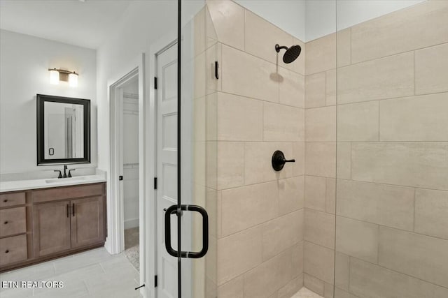 full bath with vanity, a shower stall, and tile patterned flooring