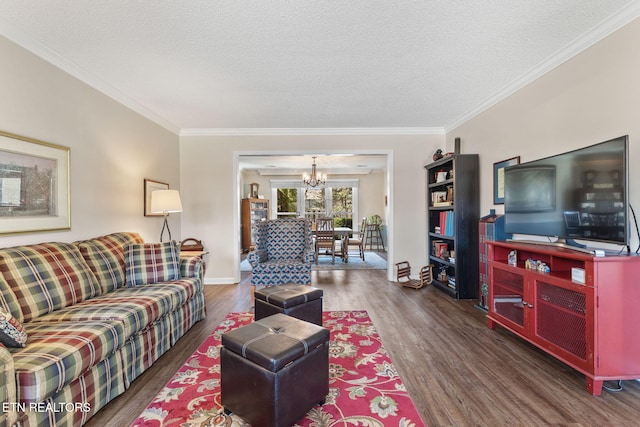 living room featuring a notable chandelier, a textured ceiling, wood finished floors, crown molding, and baseboards