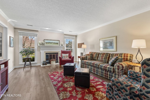 living area featuring a healthy amount of sunlight, wood finished floors, and crown molding