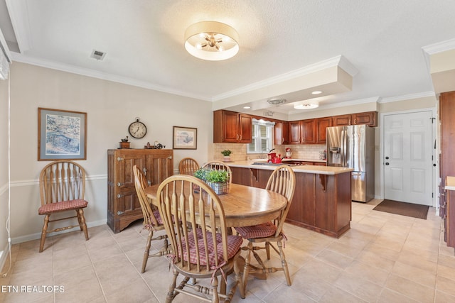 dining room featuring visible vents, ornamental molding, a textured ceiling, light tile patterned floors, and baseboards