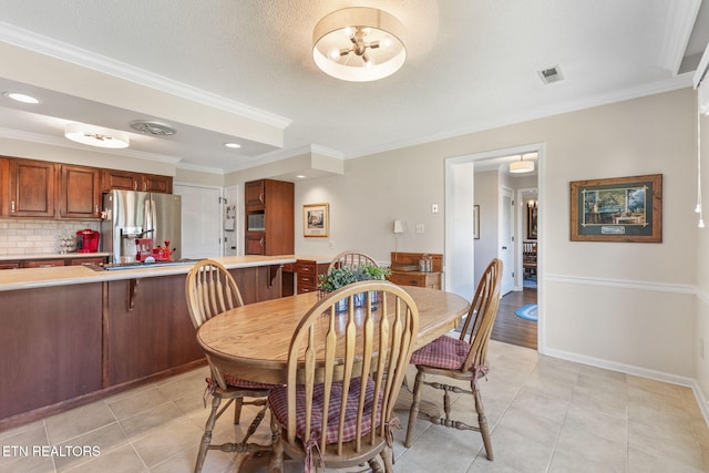 dining area with crown molding, light tile patterned flooring, visible vents, and baseboards