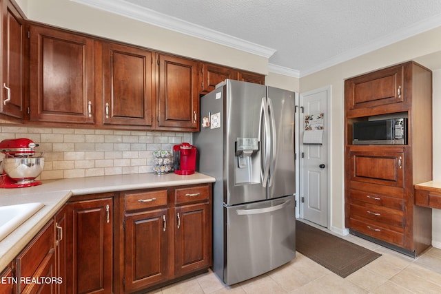 kitchen with built in microwave, ornamental molding, decorative backsplash, light countertops, and stainless steel fridge