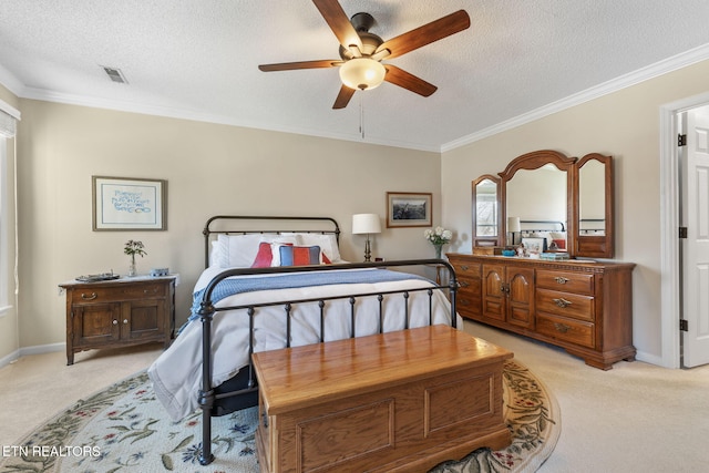 bedroom featuring a textured ceiling, crown molding, baseboards, and light carpet