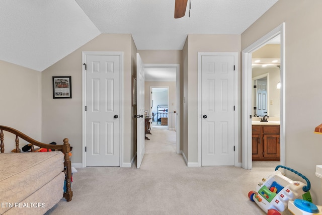 bedroom with light colored carpet, baseboards, and a textured ceiling