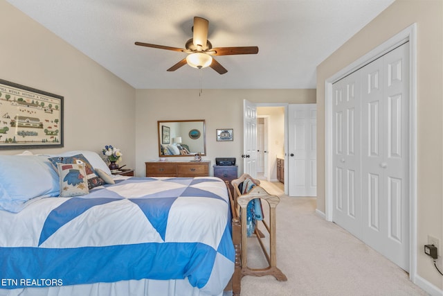 carpeted bedroom with a closet, baseboards, and a ceiling fan