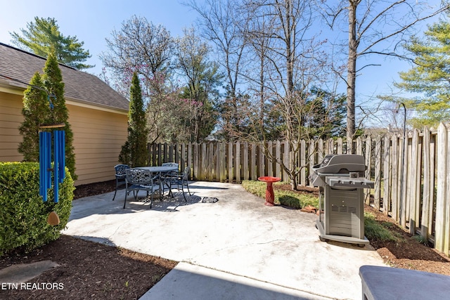 view of patio / terrace featuring a grill, outdoor dining area, and fence