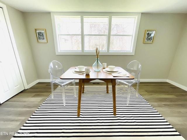 dining space featuring baseboards and wood finished floors