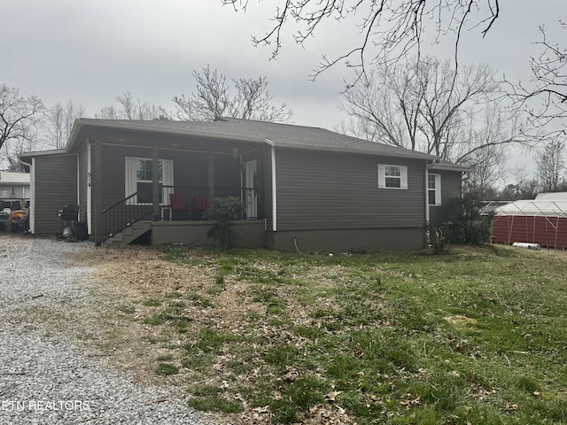 view of front of home featuring covered porch, driveway, and a front lawn