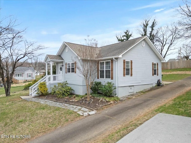 view of side of property with a yard, fence, and a shingled roof