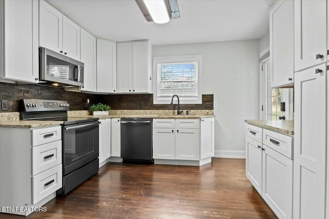 kitchen with a sink, backsplash, white cabinets, stainless steel appliances, and dark wood-style flooring