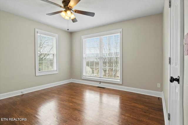 unfurnished room featuring visible vents, a ceiling fan, baseboards, and wood finished floors