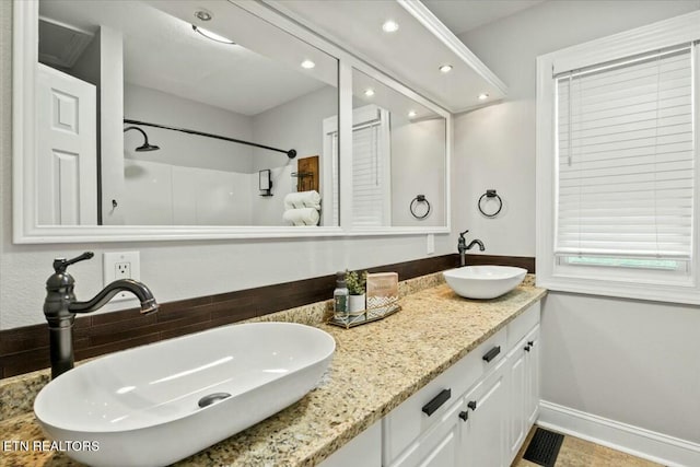 bathroom with double vanity, recessed lighting, and a sink