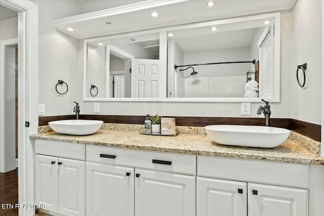 full bathroom featuring double vanity, recessed lighting, and a sink