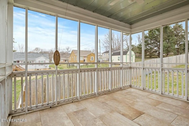 unfurnished sunroom with a wealth of natural light and a residential view