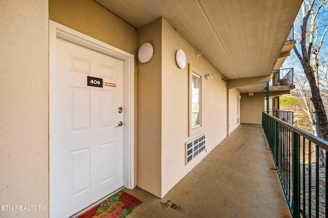 entrance to property featuring stucco siding and a balcony